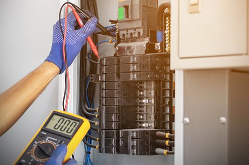 Electrician is using a digital meter to measure the voltage